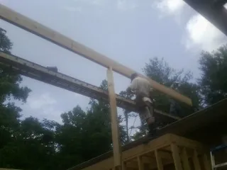 Carpenter setting a ridge beam over a new addition frame — Ice Dam Removal by Roofing Brothers in Holly Springs