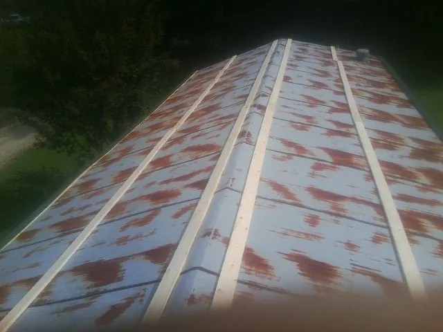 Rusted metal roof panels with new wood purlins before replacement — Storm Damage Roof Repair in Holly Springs by Roofing Brothers