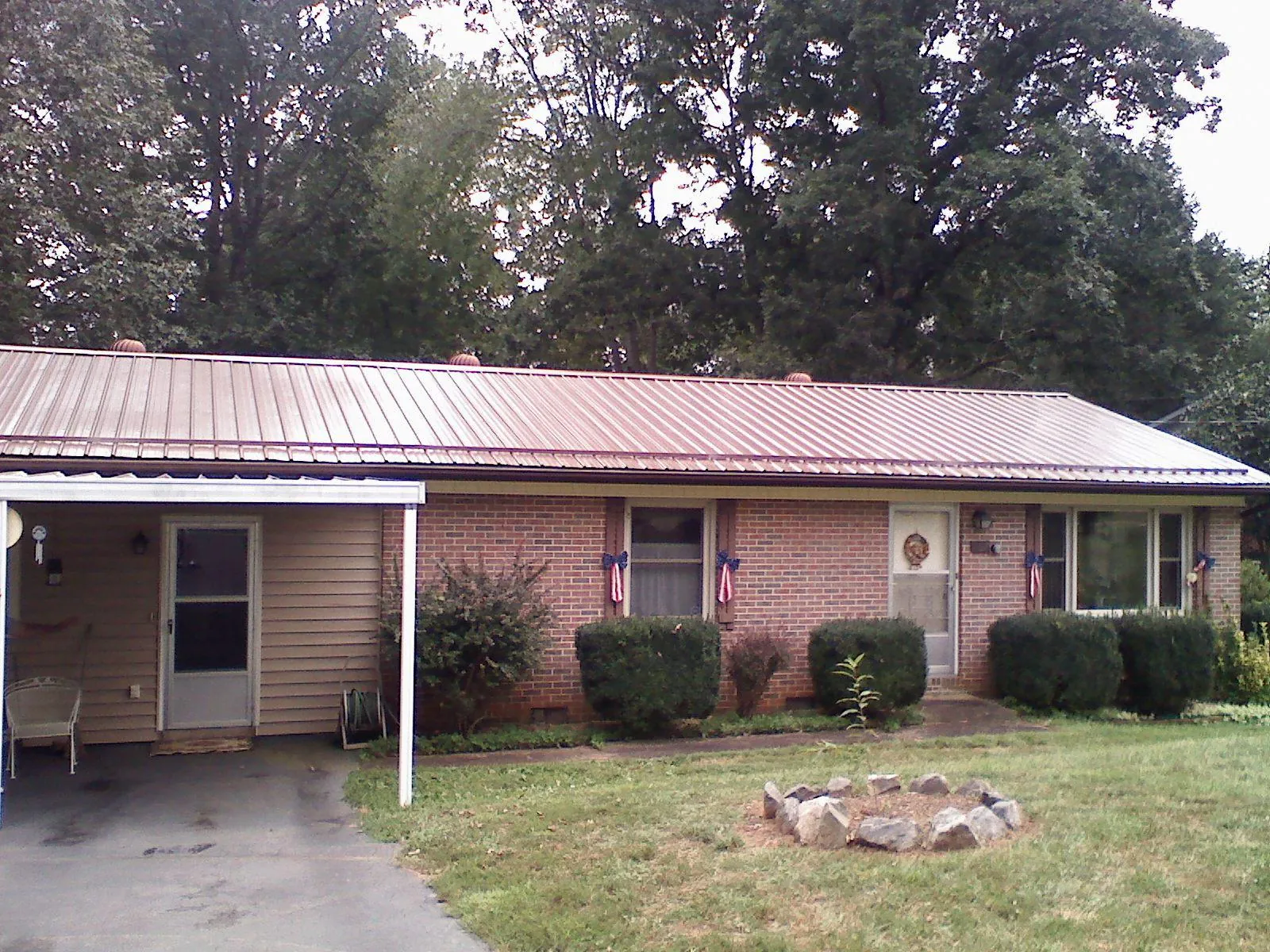 Bronze metal roof and carport on a brick ranch home — Roof Repair work by our crew in Holly Springs